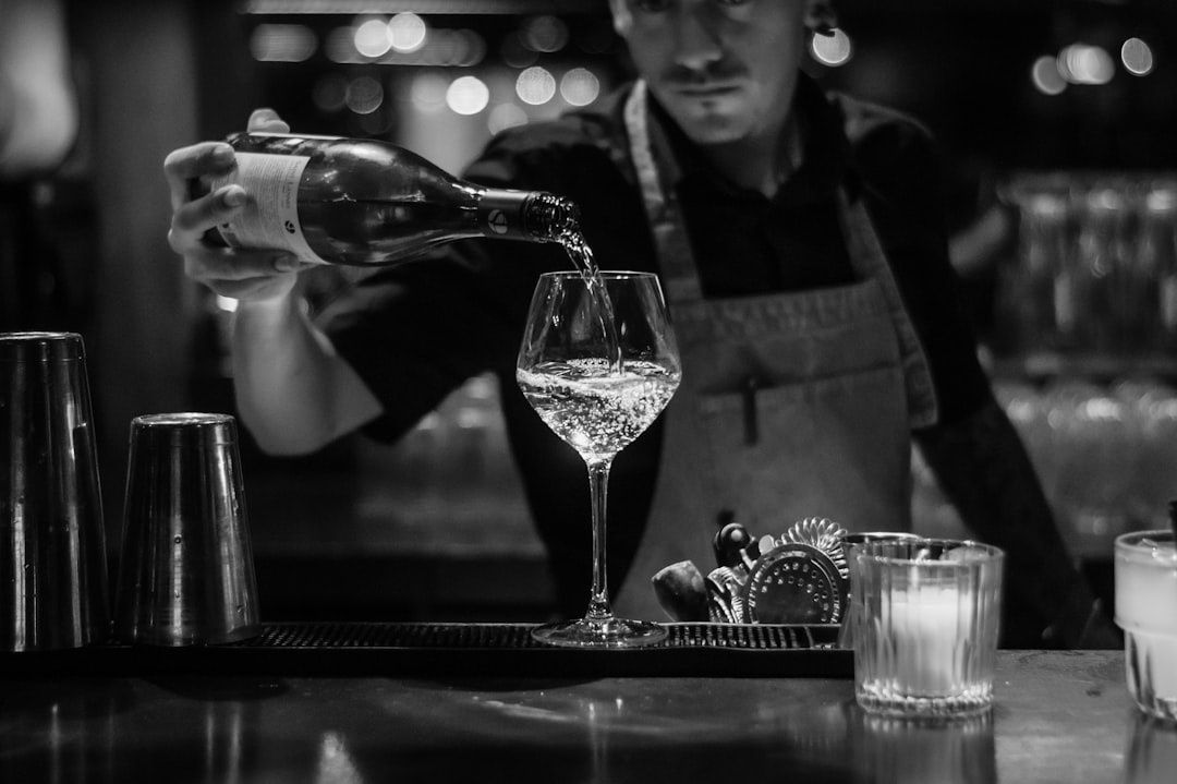 Bartender pouring sparkling wine into a glass at a bar