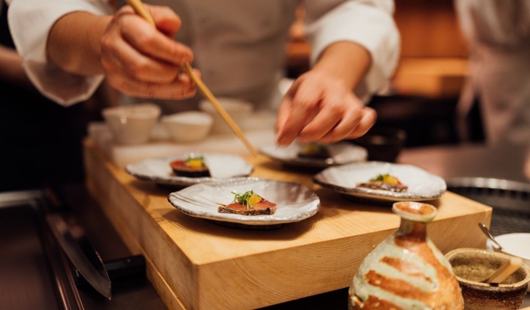 Chef arranging small tasting courses on ceramic plates