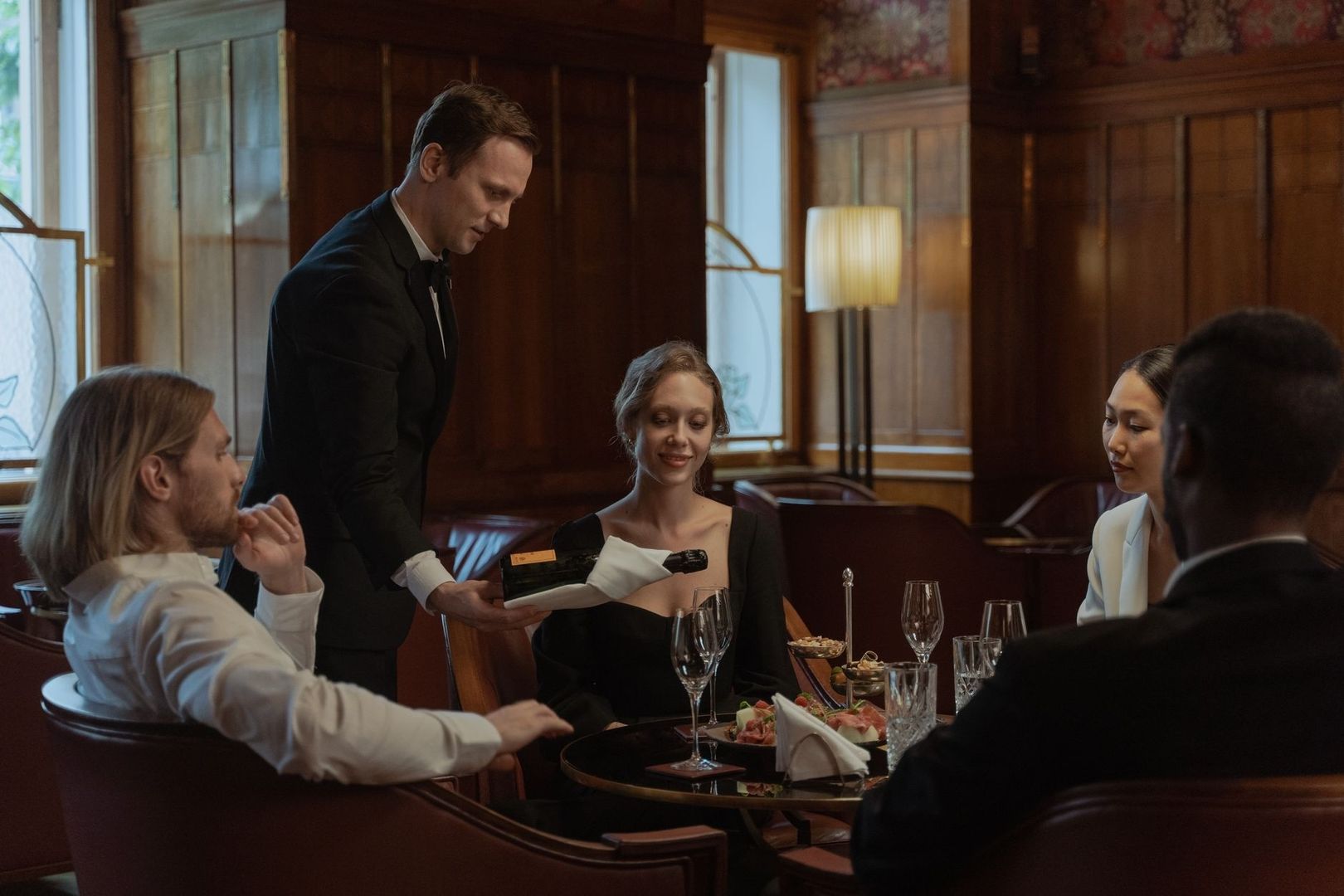 Sommelier presenting a wine bottle to diners at a restaurant table